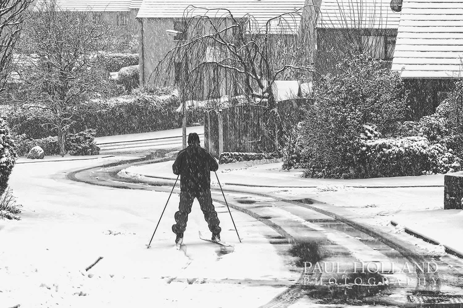 Monochrome image © Paul Holland, showing a man skiing on a residential street in Kendal